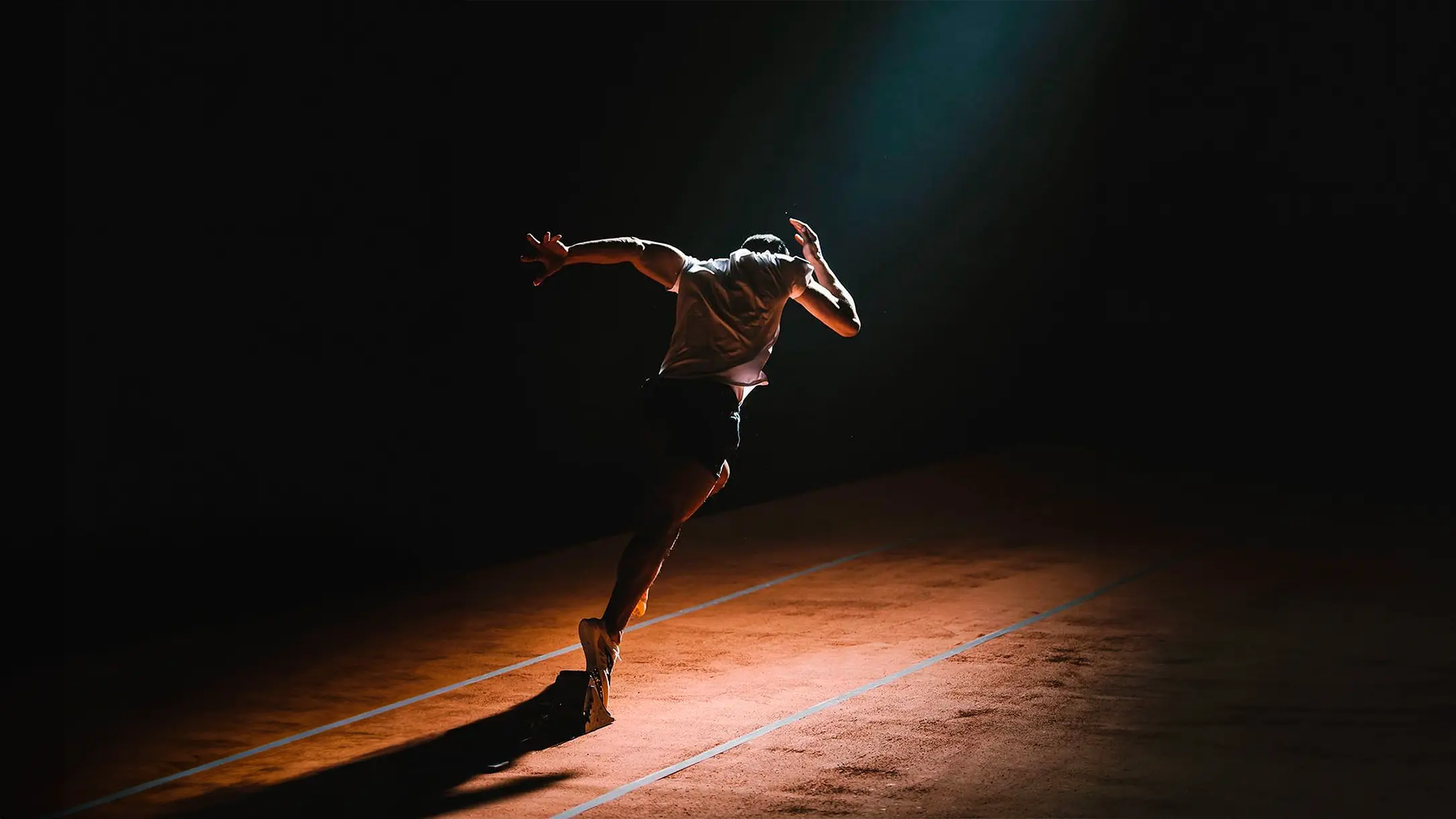 Athlete sprinting on a track under dramatic lighting, symbolizing power, speed, and the NVR5TOP "Never Stop" mindset.